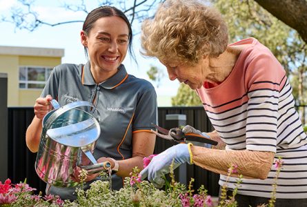 care worker and resident gardening together