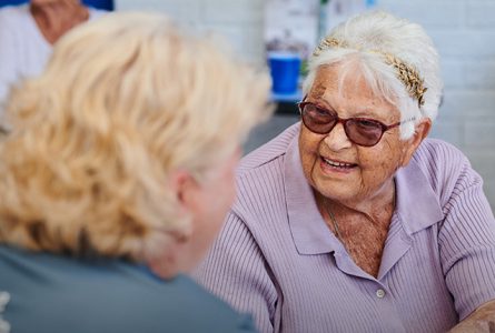 resident and care worker smiling at eachother