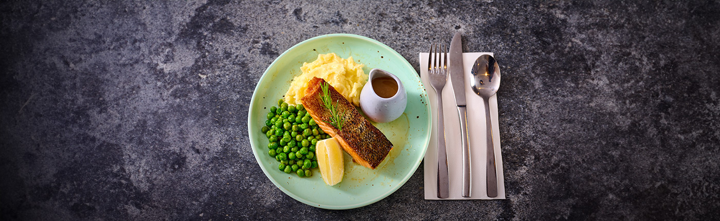plate with freshly cooked salmon, mashed potato, peas and gravy